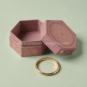Custom bracelet boxes - dusty rose hexagon two-piece cardstock bracelet box with gold mandala print and a gold bangle beside it by Pro Packaging Line