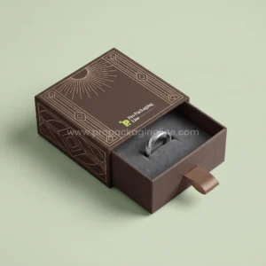Custom ring box: mocha matchbox-style slide drawer ring box with ribbon pull and art-deco gold lines, Pro Packaging Line logo