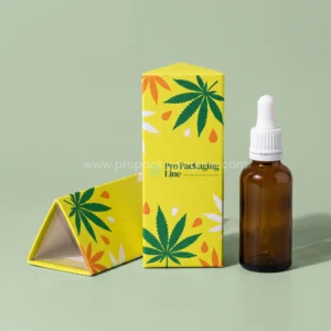Custom lemon yellow triangular prism tincture boxes with hemp leaf print beside an amber dropper bottle