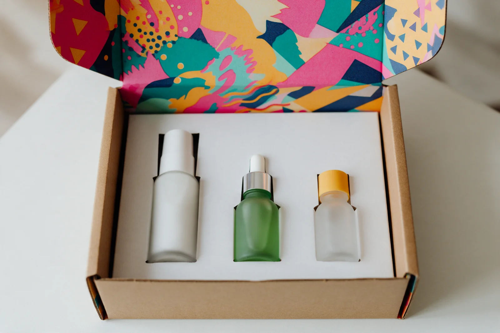 Custom kraft mailer box with inside printing and a paperboard insert holding skincare bottles